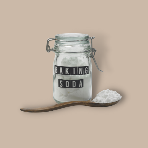 bottle of baking soda and a spoonful of baking soda against brown background