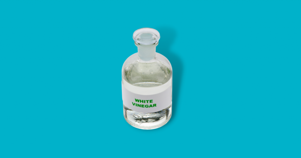a bottle of white vinegar against blue background
