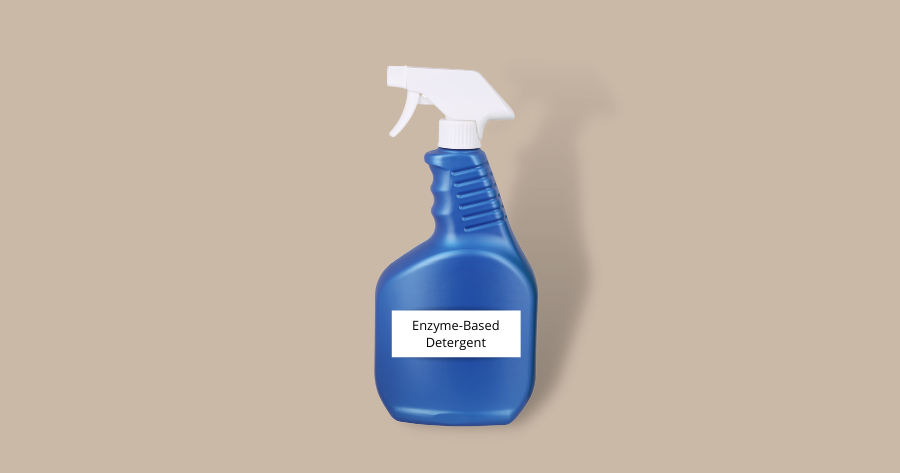 blue spray bottle of enzyme based detergent against brown background