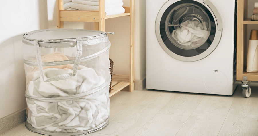 laundry hamper and clothes washer in a laundry room