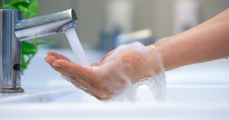 running water from a faucet to a hand