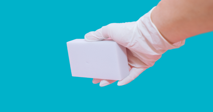 hand with latex gloves holding a melamine foam cleaner