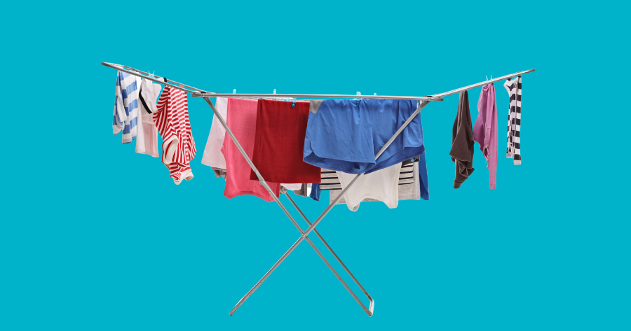 clothes drying rack with clothes on against blue background